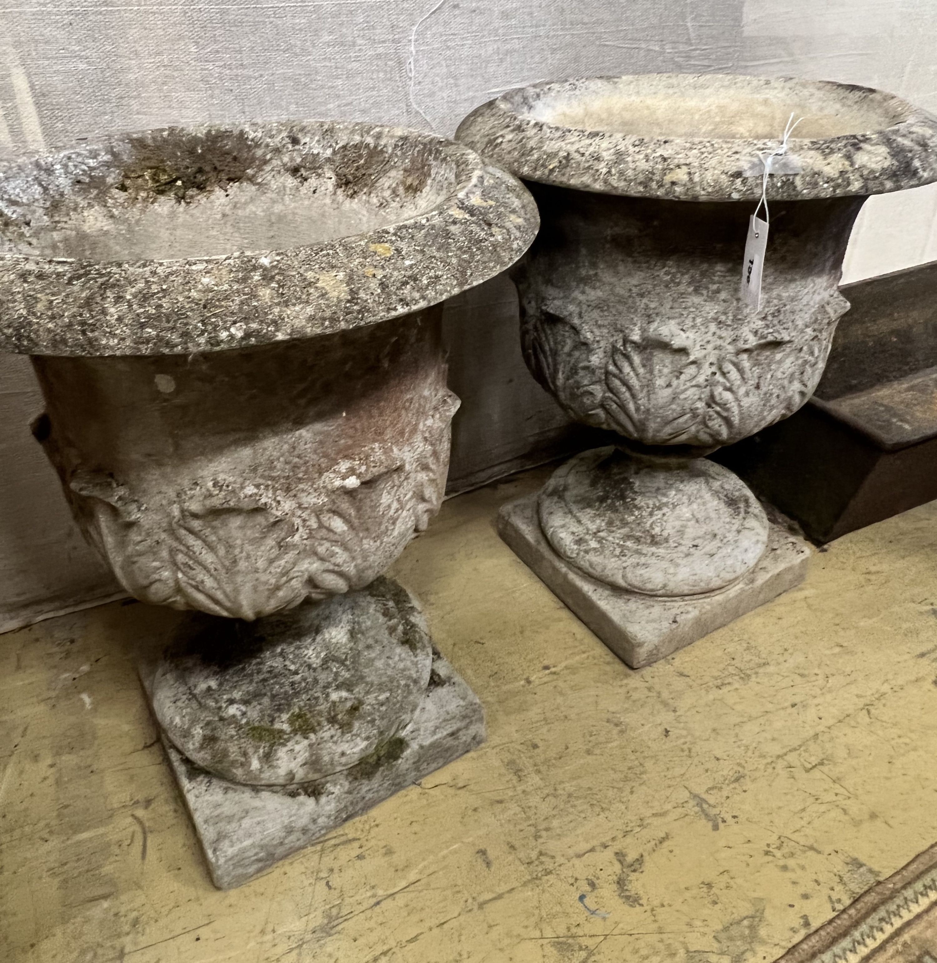 A pair of reconstituted stone acanthus moulded circular campana garden urns, diameter 49cm height 61cm